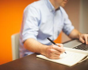 homme avec carnet et ordinateur